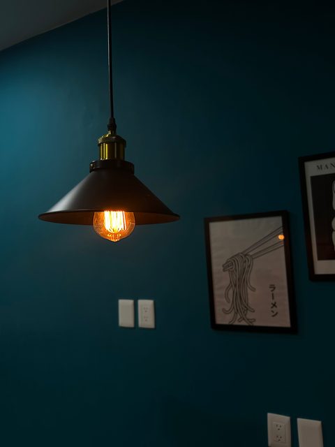 Warm pendant lamp and ramen poster on the blue wall